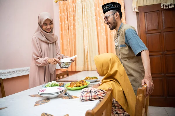 Ibu muslim melayani beberapa makanan untuk makan malam keluarga — Stok Foto