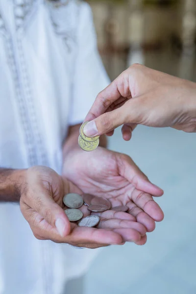 Hand giving some money to someone at the mosque — Stock Photo, Image
