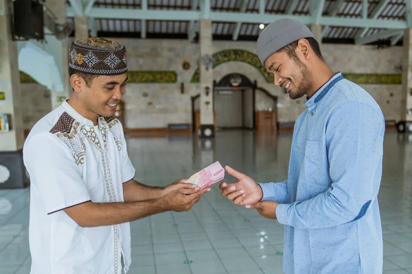 Muslim membayar beberapa zakat menggunakan uang tunai di masjid — Stok Foto