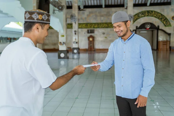 Muslim man ger zakat välgörenhet för eid mubarak i moskén — Stockfoto