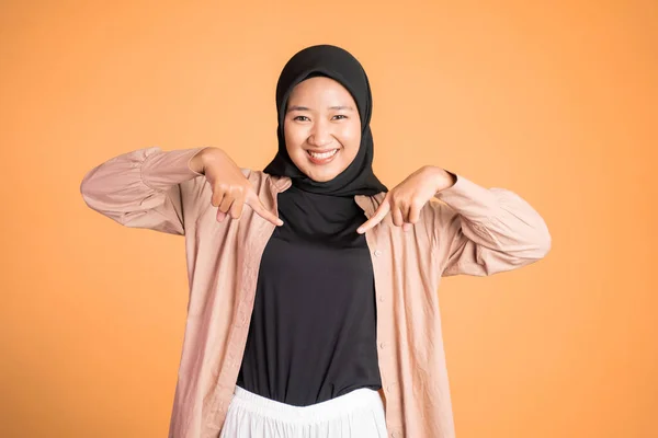 Wanita hijab tersenyum dengan jari menunjuk ke bawah tangan gerakan — Stok Foto