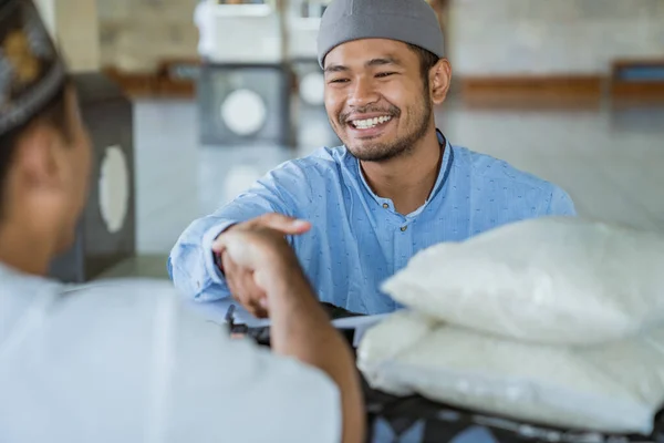 Muslim man shaking hand while giving a donation for zakat charity — Stock Photo, Image