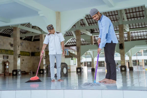 Musulmano maschio pulizia della moschea con scopa e spazzare il pavimento — Foto Stock