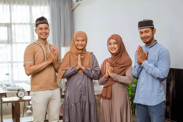 Мусульмане с приветственным жестом смотрят в камеру и улыбаются — стоковое фото