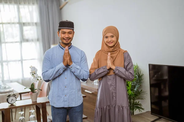 Мусульманская пара с приветственным жестом смотрит в камеру и улыбается — стоковое фото