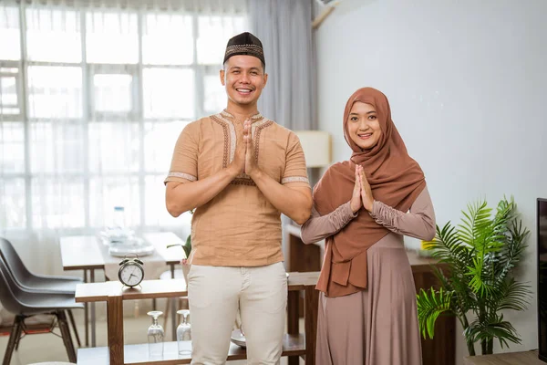 Muzułmańska para z gestem powitania patrząc w kamerę i uśmiechając się — Zdjęcie stockowe