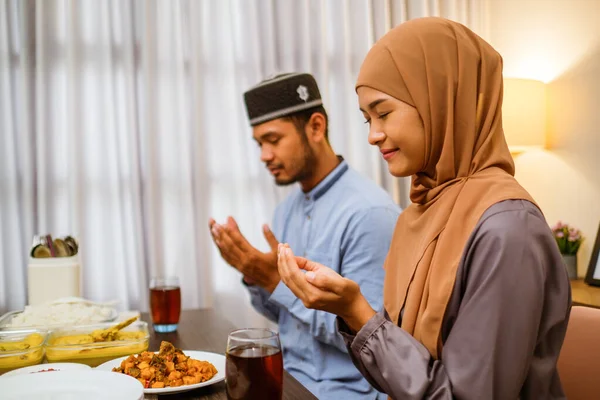 Casal muçulmano orando antes de parar de jejuar iftar jantar juntos — Fotografia de Stock