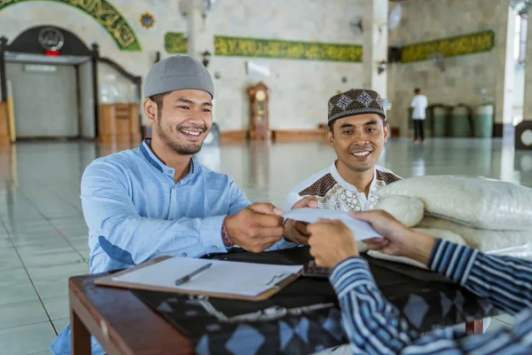 Muslim man giving zakat charity for eid mubarak at the mosque — Stock Photo, Image