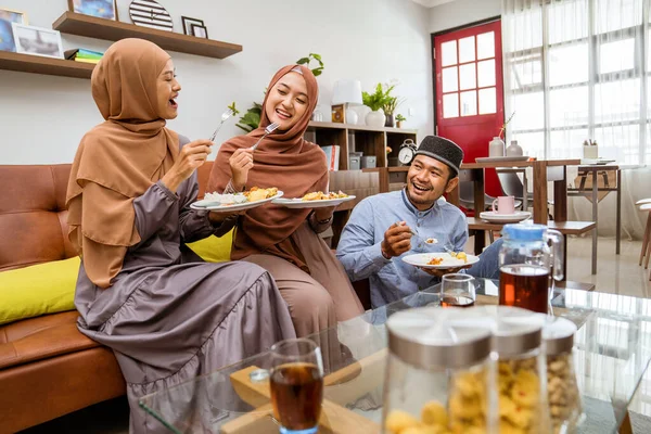 Teman makan malam iftar bersama-sama sambil duduk di lantai di ruang tamu — Stok Foto