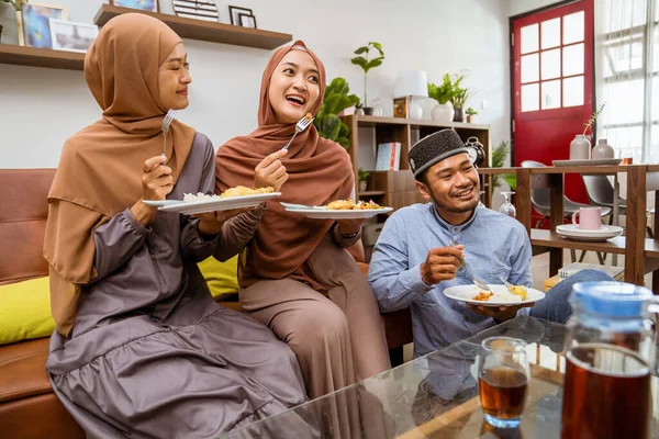 Muçulmanos pessoas tendo iftar jantar sentado no sofá — Fotografia de Stock