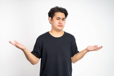 İki eli de açık bir adam sorgulama ifadesiyle ileriye bakıyor.