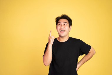 Parmakları havada gülümseyen Asyalı adam