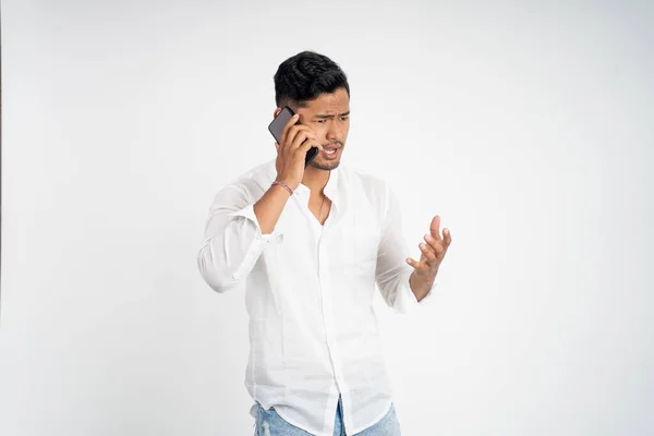 Homem chocado e irritado ao falar em seu smartphone — Fotografia de Stock