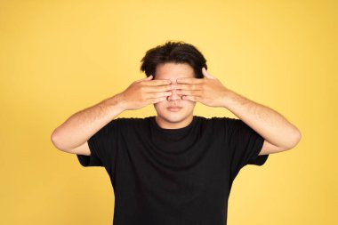 Elleri havada genç bir adam gözlerini kapatıyor.