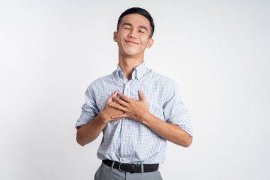 Genç adam göğsünü tutuyor rahatlıyor ve kendini rahatlatıyor.