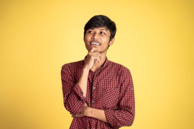 Asyalı adam bir şey düşünüyor ve yukarı bakıyor.