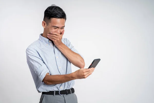 Junger asiatischer Geschäftsmann lacht beim Anblick seines Telefons — Stockfoto