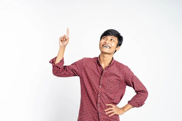 Sonriente joven con el dedo apuntando hacia arriba — Foto de Stock