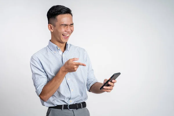 Junger asiatischer Geschäftsmann lacht beim Anblick seines Telefons — Stockfoto