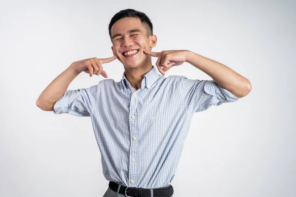 Hombre sonriendo y haciendo un gesto lindo puso su dedo en las mejillas —  Fotos de Stock