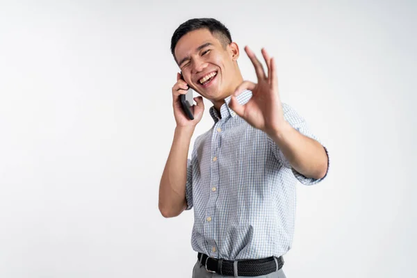 Мужчина показывает хороший жест во время телефонного звонка — стоковое фото