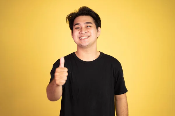 Asiático jovem homem mostrando polegares para cima com sorrir dentes — Fotografia de Stock