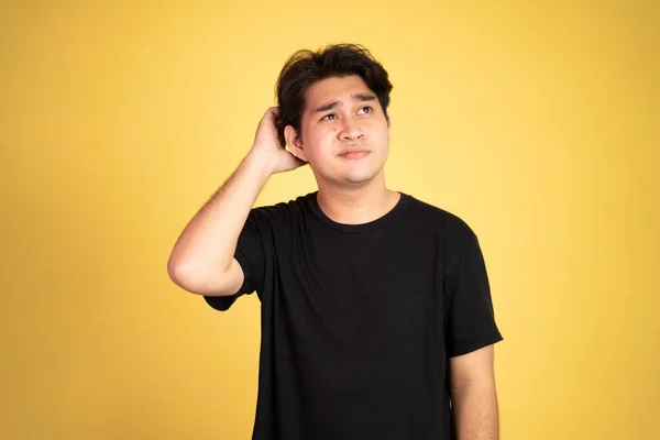 Inseguro asiático joven hombre usando negro camisa — Foto de Stock