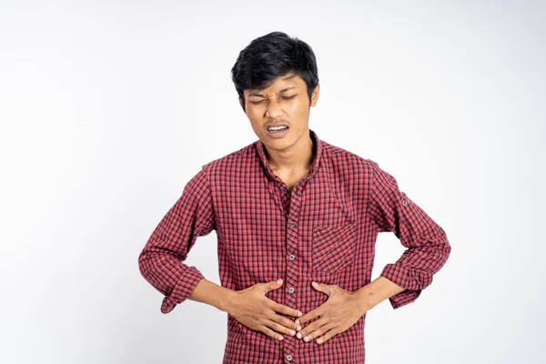 Man having stomachache holding his stomach with two hands — ストック写真