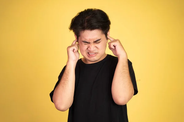 Man met ongemakkelijke uitdrukking met vingers die oren bedekken — Stockfoto