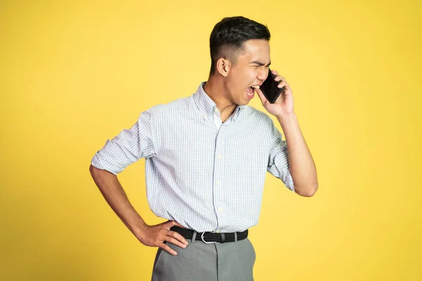 Muž šokován a naštvaný, zatímco mluví na svém smartphonu — Stock fotografie