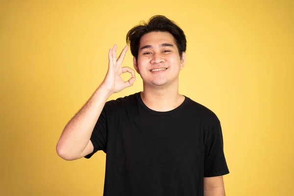 Azji młody człowiek pokazując w porządku ręka gest z uśmiechem — Zdjęcie stockowe