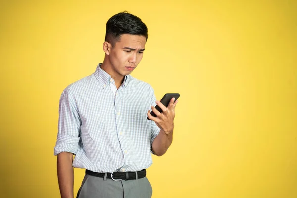 Zdezorientować młodego biznesmena patrząc na jego smartfon — Zdjęcie stockowe