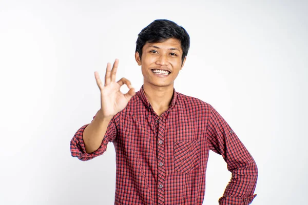 Asiatisk ung mann som viser tommelen opp med smilende tenner – stockfoto