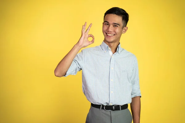 Aziatische jongeman tonen oke hand gebaar met glimlachen — Stockfoto