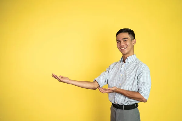 Asijský muž se usmívá s oběma rukama představuje něco — Stock fotografie