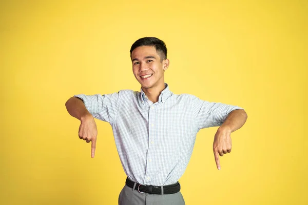 Upphetsad ung man med fingrarna pekande nedåt — Stockfoto