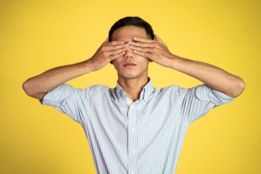 Elleri havada genç bir adam gözlerini kapatıyor.