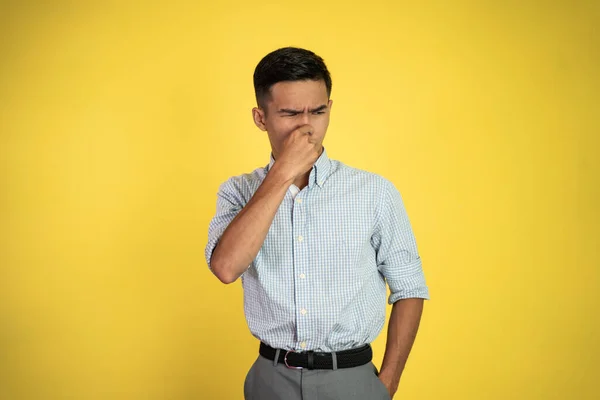 Man cover his nose and feeling disgusted by the smell — Stock Photo, Image