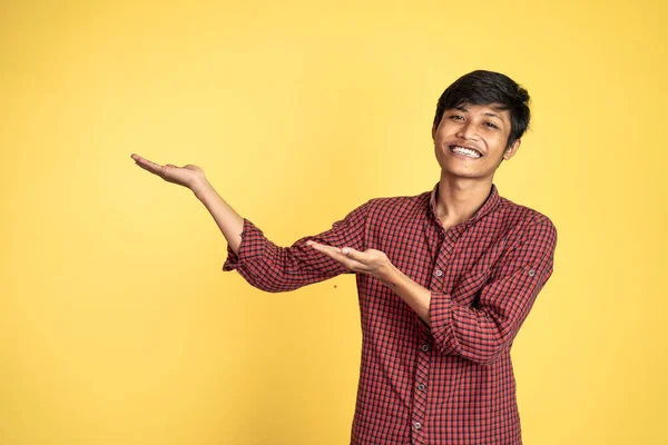 Asiático hombre sonriendo con ambos manos presentando algo —  Fotos de Stock