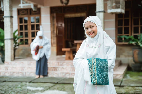 tesettürlü müslüman kız gülümsüyor ve kameraya selam veriyor.