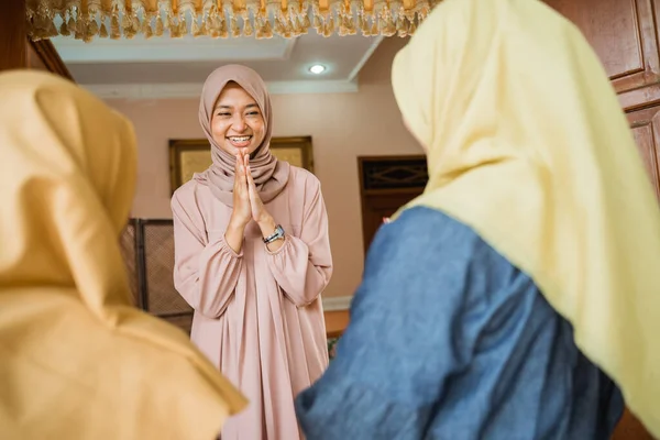 Мусульманская женщина приветствует гостей дома на празднике Мубарака — стоковое фото
