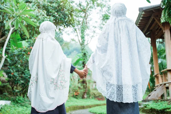 Mãe muçulmana e filha caminhando para a mesquita enquanto vestindo hijab — Fotografia de Stock