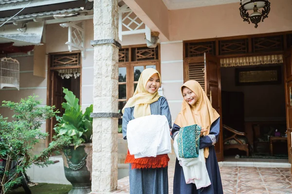 Müslüman anne ve kızı İdul Fitri duasına hazırlanıyorlar.