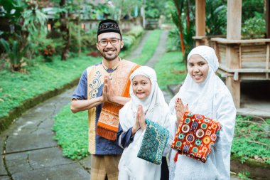 Müslüman aile kameraya bakarken jest yapıyor.