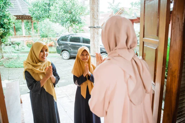 Mujer musulmana dando la bienvenida a los huéspedes en casa en eid mubarak — Foto de Stock