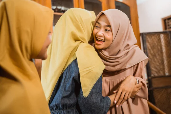 Мусульманская женщина обнимает и целует друг друга во время семейного визита — стоковое фото