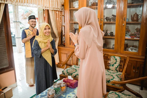 Muslimsk kvinna välkomnar gäster hemma på eid mubarak — Stockfoto