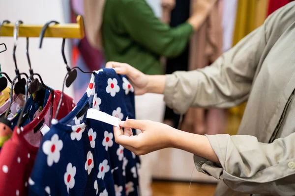 Gesto delle donne mano guardando il cartellino del prezzo al negozio di moda — Foto Stock