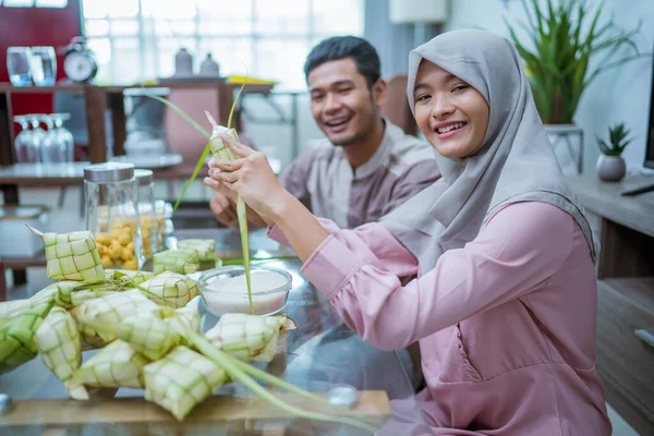 Casal muçulmano fazendo ketupat para idul fitri iguaria tradicional — Fotografia de Stock