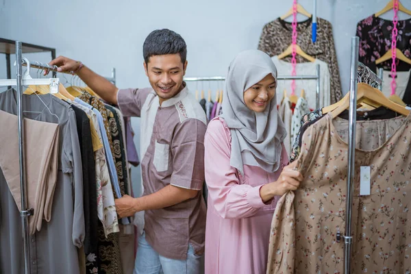 Мусульманська жінка купує якусь сукню для ідул-фітрі зі своїм чоловіком — стокове фото